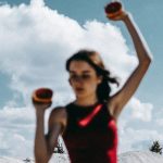 a woman holding two oranges in her hands